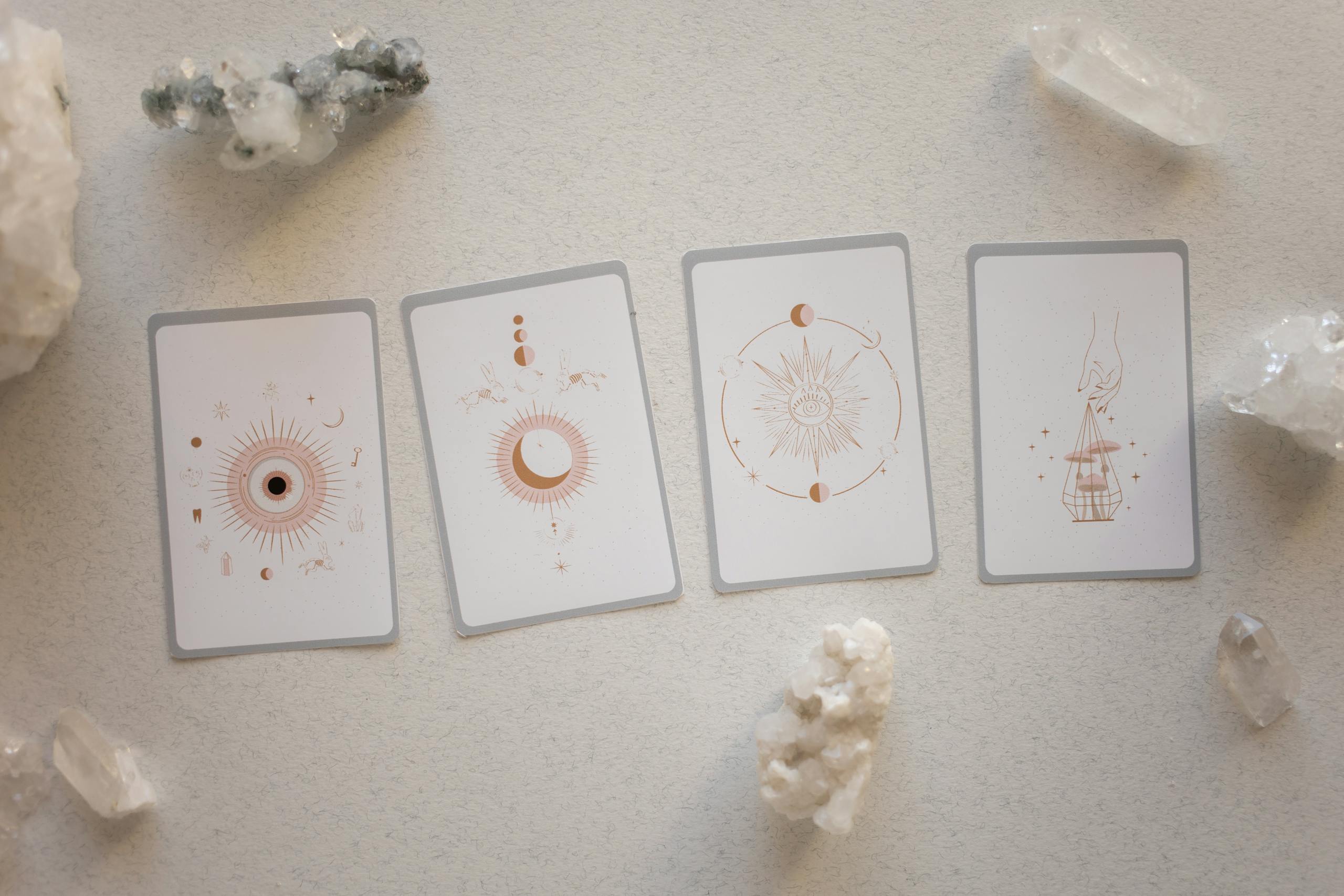 Cuatro cartas de tarot evolutivo sobre una superficie clara, rodeadas de cristales energéticos